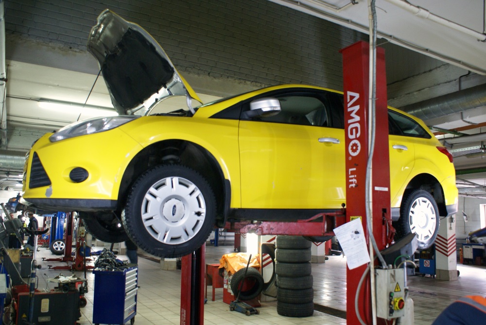 желтый Форд на подъемнике